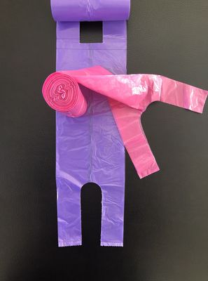 Sacchetti della spesa della maglietta sull'ufficio del rotolo ed uso, rosa e porpora domestici, pattumiera della Tabella