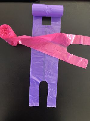 Sacchetti della spesa della maglietta sull'ufficio del rotolo ed uso, rosa e porpora domestici, pattumiera della Tabella